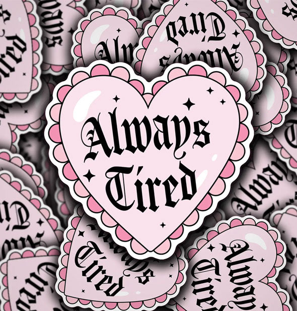 Grouping of pink heart-shaped stickers that say, "Always Tired" in black gothic lettering inside a frilly border