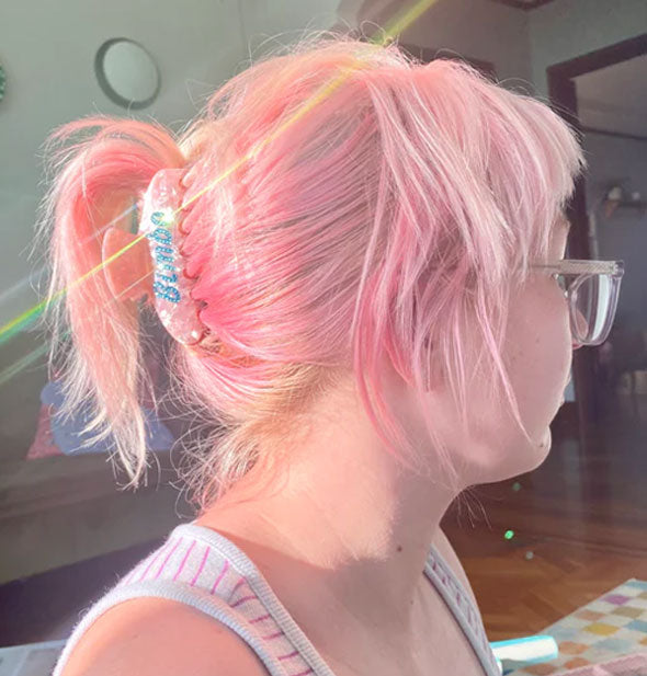 Model with pink hair wears the Bimbo claw clip in a swept-back updo