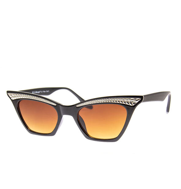 Pair of angular black cat-eye sunglasses with metallic frame embellishment and amber lenses