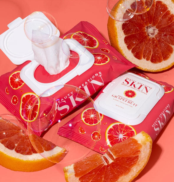 One closed and one opened pack of Brightening Grapefruit Beauty Creations Skin Makeup Remover Wipes staged with grapefruit slices and bubbles