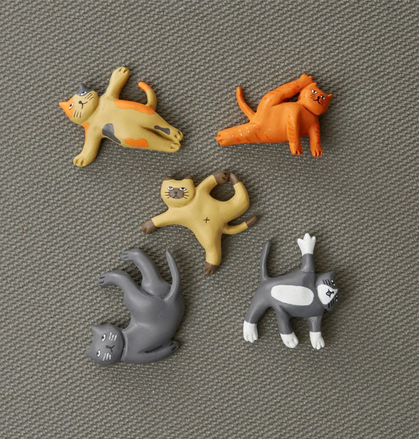 Cat Yoga Magnets on a textured gray surface