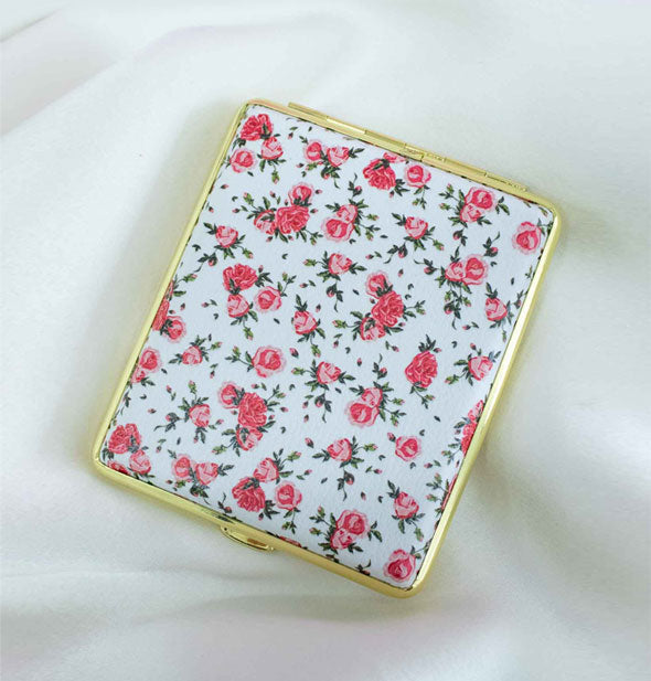 Rectangular white case with gold rim features delicate vintage-inspired rose print