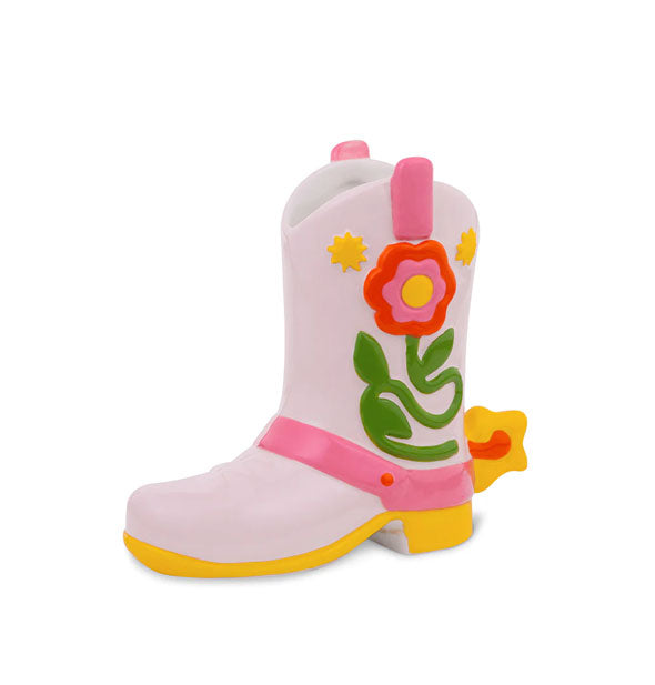 Cowboy boot-shaped vase with opening at top features floral design on the side with pink strap accents and yellow spur, sole, and heel details