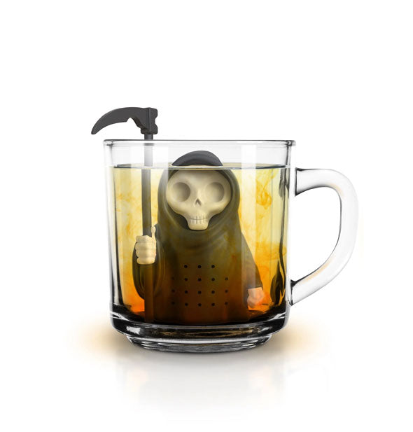 Grim Steeper infuser is submerged in a clear glass mug of tea