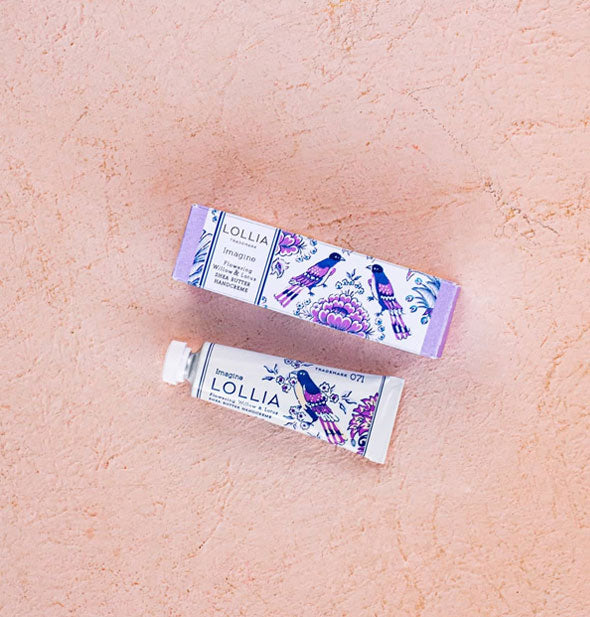 Mini white tube and box of Lollia Imagine Handcreme with blue and purple floral and birds design on each