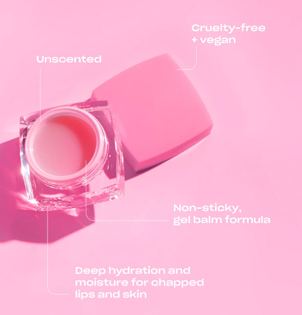 Opened pot of lip mask on pink surface is labeled with its benefits: Unscented; Cruelty-free + vegan; Non-sticky, gel balm formula; Deep hydration and moisture for chapped lips and skin