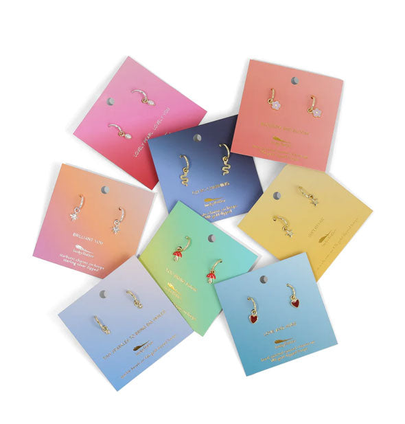Grouping of dainty charm hoop earrings on colorful product cards
