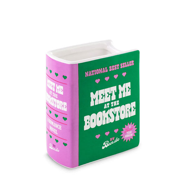 Purple, green, and white book-shaped ceramic vase says, "Meet Me at the Bookstore"