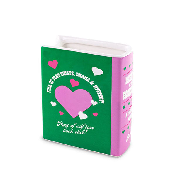 Purple, green, and white ceramic book-shaped vase says, "Full of plot twists, drama & myster!" Part of self-love book club!"