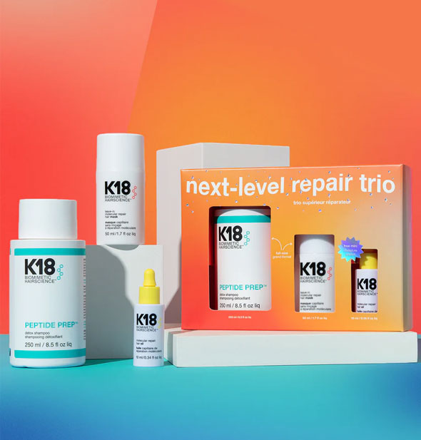 Next-Level Repair Trio by K18 shown inside and out of packaging: Peptide Prep Detox Shampoo, Leave-In Molecular Repair Hair Mask, and Molecular Repair Hair Oil