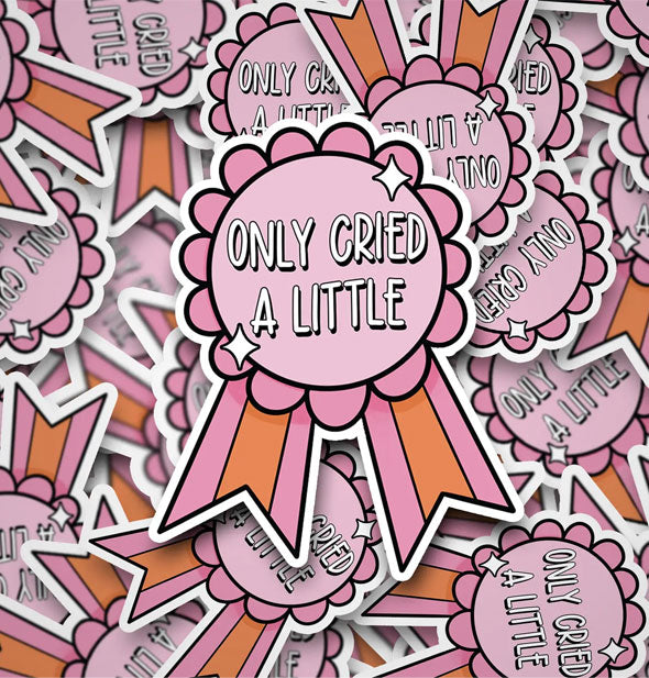 Grouping of stickers designed as pink and orange ribbons that say, "Only cried a little" in white lettering accented with small white stars