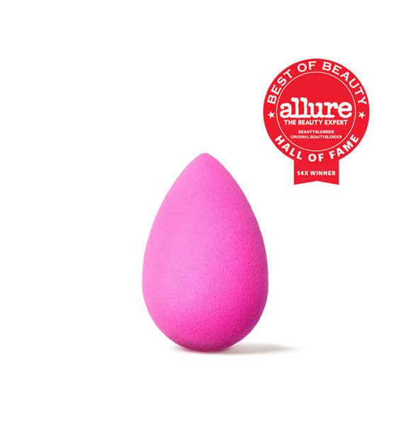 Pink teardrop-shaped makeup sponge with red Allure Best of Beauty Hall of Fame seal in upper right corner