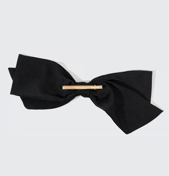 Back of black fabric bow features a gold clip