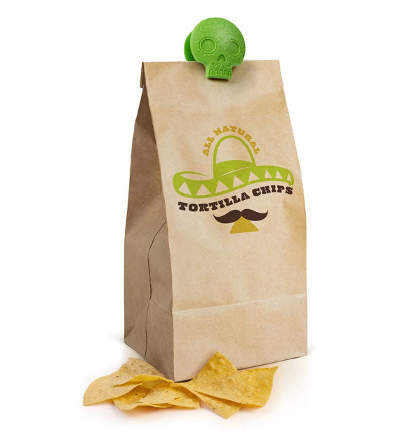 Green sugar skull clip secures a brown paper bag of tortilla chips, some of which are removed and placed at its base
