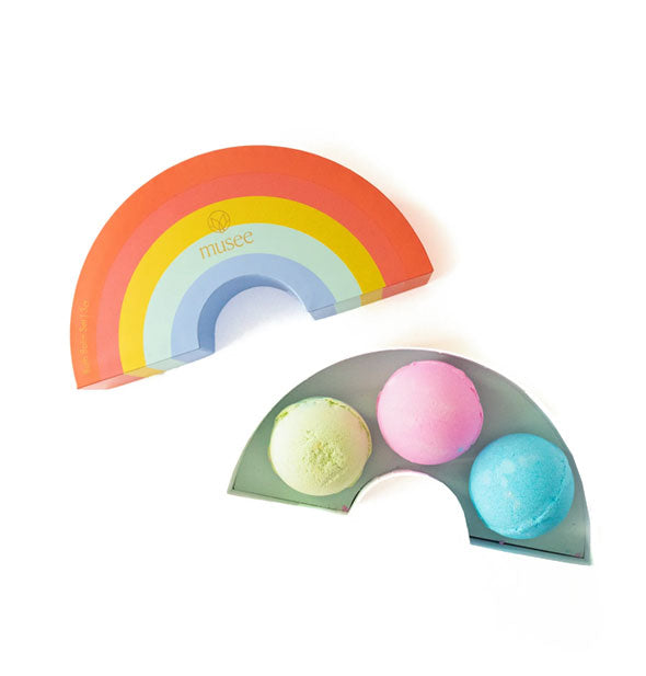 An opened rainbow box with Musee logo reveals three pastel-colored bath bombs inside