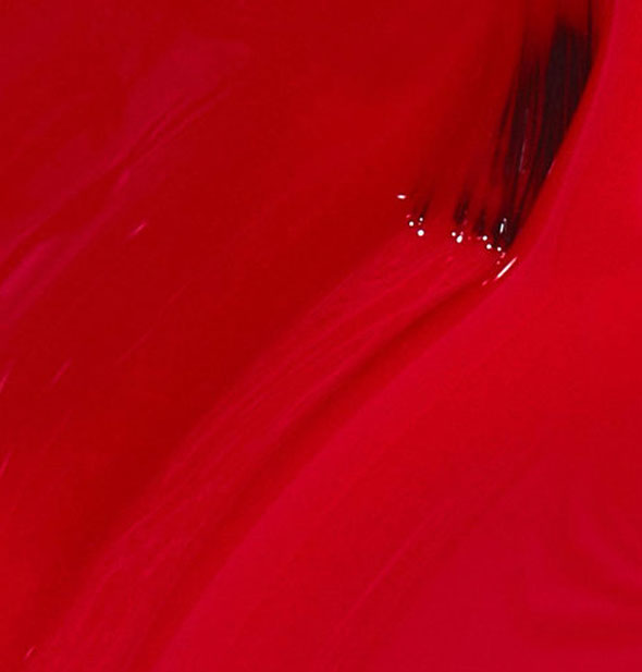 Closeup of red nail polish with brush tip drawn through it