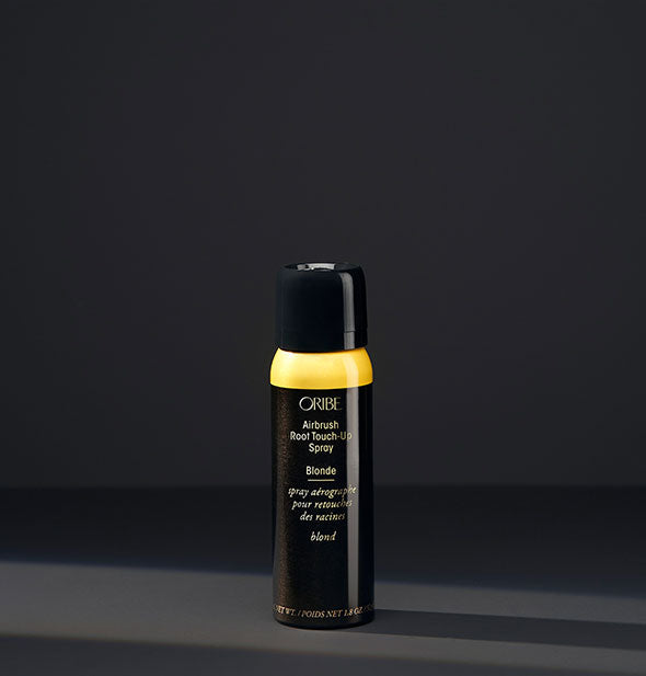 Small can of Oribe Airbrush Root Touch-Up Spray in the shade Blonde on a dark background