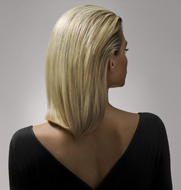 Model shown from behind with a slicked-back, straight hairstyle to show results of using Oribe's Crème for Style