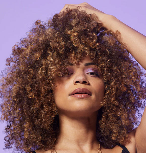 Model with tight curl pattern demonstrates the results of using Bumble and bumble Curl Moisturizing Shampoo
