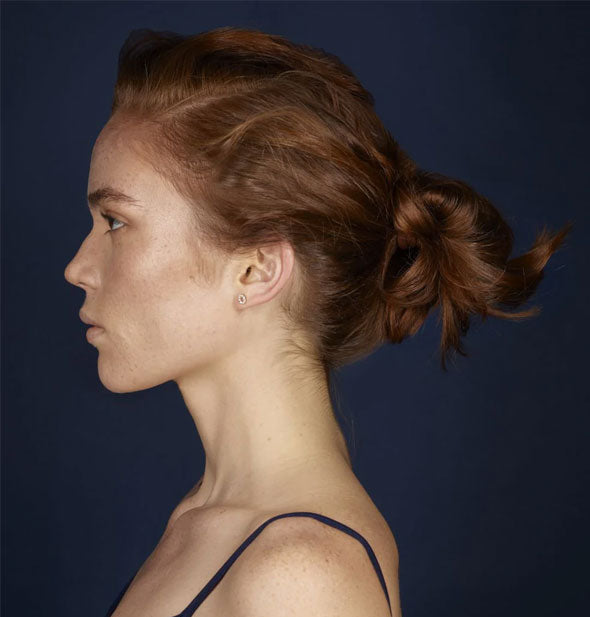 Profile of model with swept-back low, messy bun hairstyle