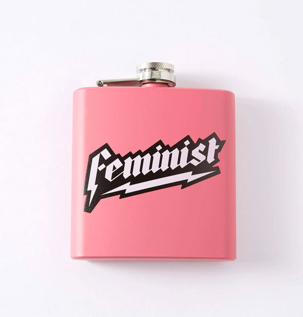 Square pink flask says, "Feminist" in black and white jagged lettering