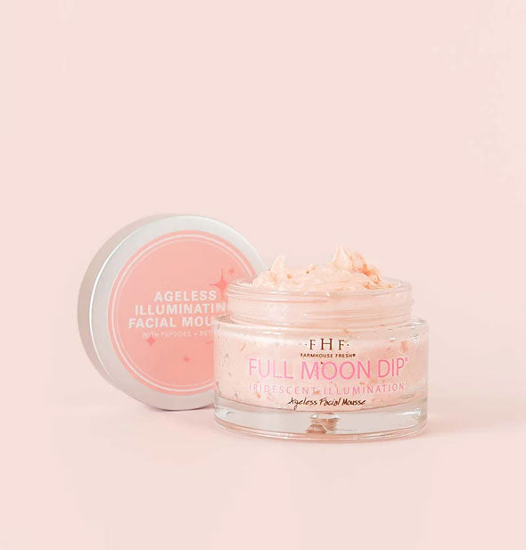 Pot of FarmHouse Fresh Full Moon Dip Iridescent Ageless Illumination Facial Mousse with lid removed on pink background