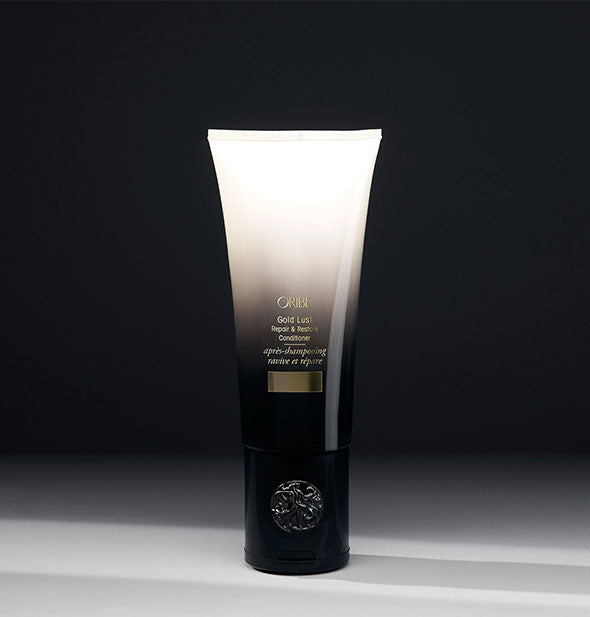 6.8 ounce black-to-white bottle of Oribe Gold Lust Repair & Restore Conditioner on gray background