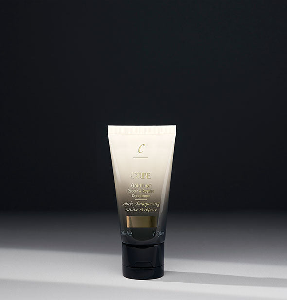 1.7 ounce black-to-white bottle of Oribe Gold Lust Repair & Restore Conditioner on gray background