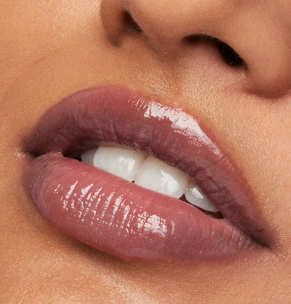 Model's lips are plumped, tinted, and shiny with an application of Babe Glow Plumping Lip Jelly