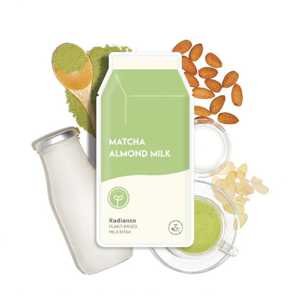 Carton-shaped Matcha Almond Milk sheet mask packet rests on top of a glass milk bottle, green matcha powder, and loose almonds