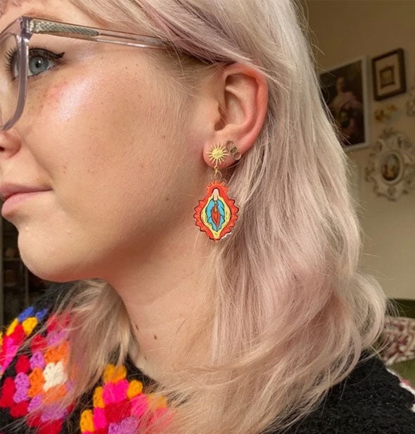 Model wears Vulva Mary earrings to demonstrate size