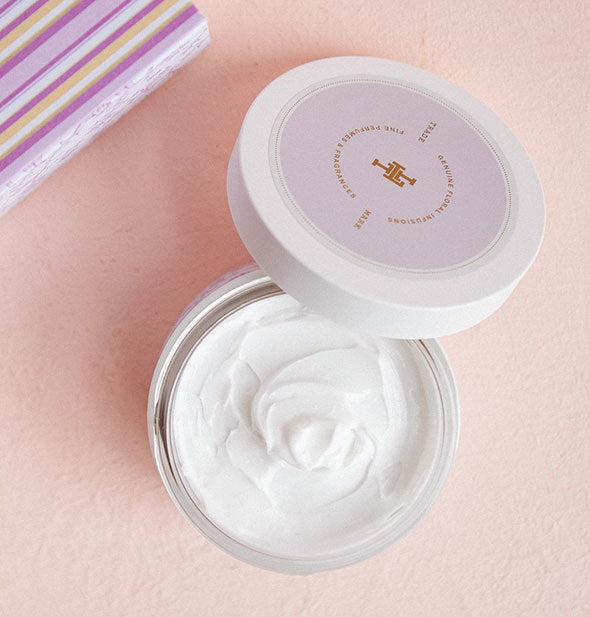 Opened jar of Lollia body butter shows creamy white product inside