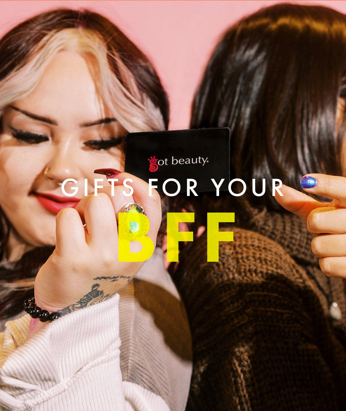 Models with backs together pass a black Got Beauty gift card between them with caption, "Gifts for your BFF" overtop in white and yellow lettering