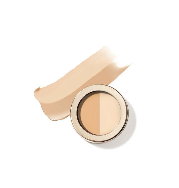 Round pot of Jane Iredale two-tone Circle\Delete Concealer with gold rim and sample product application behind in shade #1 - Light/Medium Yellow