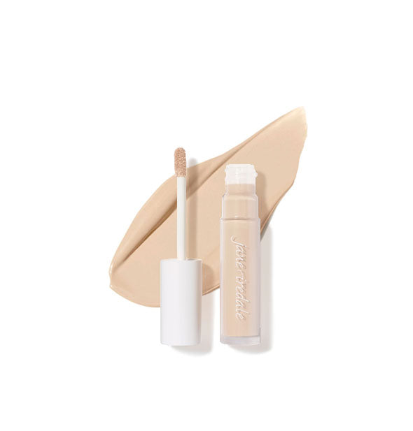 Clear tube of Jane Iredale concealer with doe foot applicator cap removed rests on top of an enlarged sample product application in shade 2N