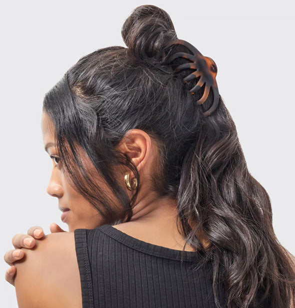 Model wears a matte brown tortoise octopus-style claw clip in a twisted half-up hairstyle