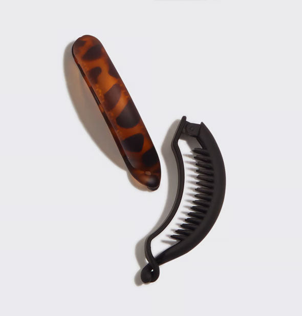 Brown tortoise hair clip and black hair clip laying on its side to show teeth pattern and curved shape