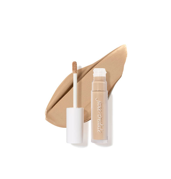 Clear tube of Jane Iredale concealer with doe foot applicator cap removed rests on top of an enlarged sample product application in shade 6N