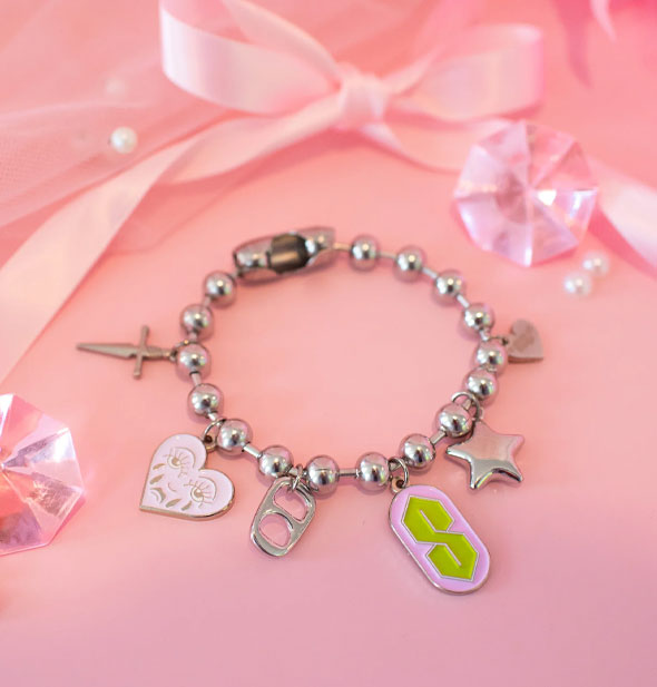 Silver bracelet with large ball chain features dagger, enamel crying heart, soda can tab, enamel 90s "S", star, and heart charms