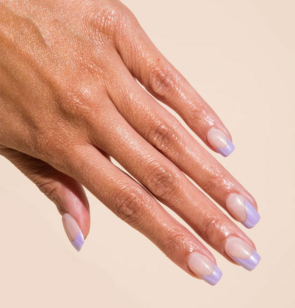 Model's hand wears a metallic purple wavy French tip manicure with square shape