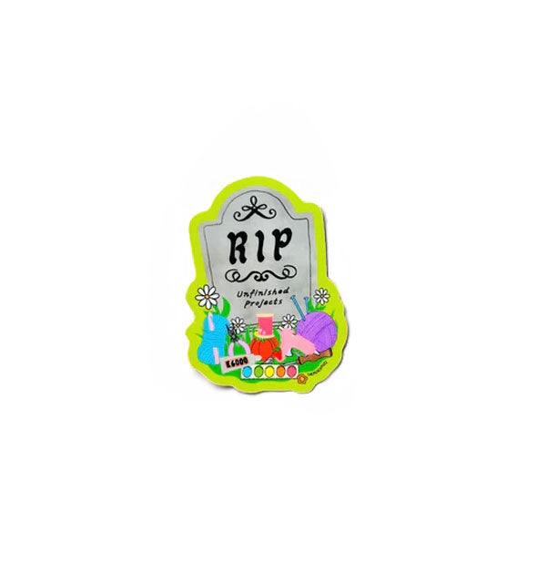 Sticker designed as a gray headstone that says, "RIP Unfinished Projects" with thread, yarn, paint pallette, and other crafty items at its base