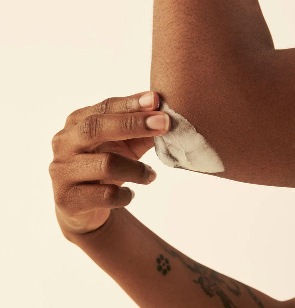 Model applies All Body Butter to elbow