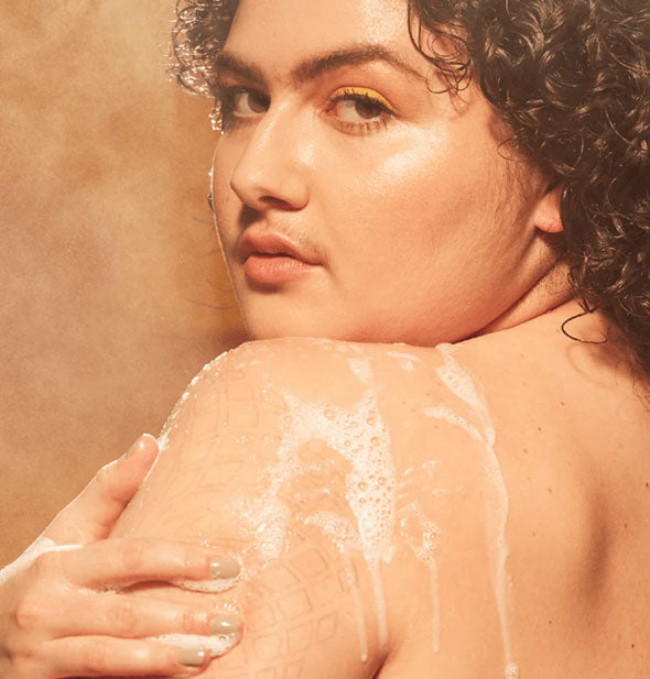 Model lathers shoulder with body wash