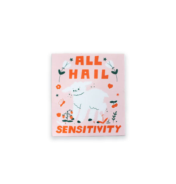 Rectangular sticker with illustration of a white lamb flanked by florals, fruits, and butterflies says, "All hail sensitivity" in orange blocky lettering