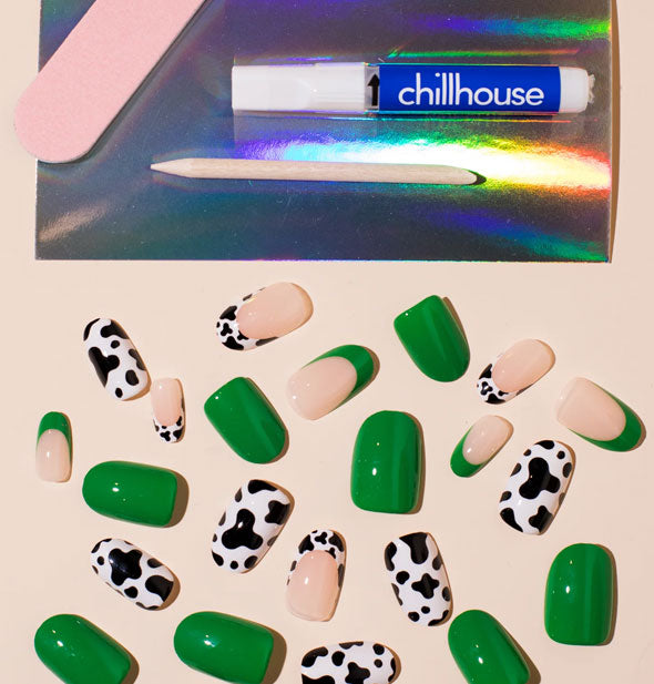 Contents of the Animal House Chillhouse press-on nail kit: Nails in an assortment of styles and sizes, pink file, wooden cuticle pusher, and glue tube