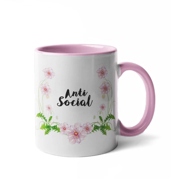 Coffee mug with pink interior, pink handle, floral accents, and black "Anti Social" lettering