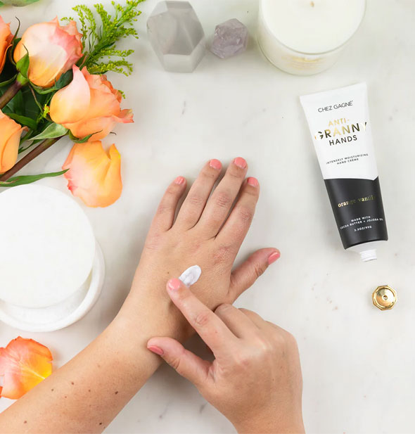 Model applies Anti-Granny Hands moisturizer to back of hand with fingertip