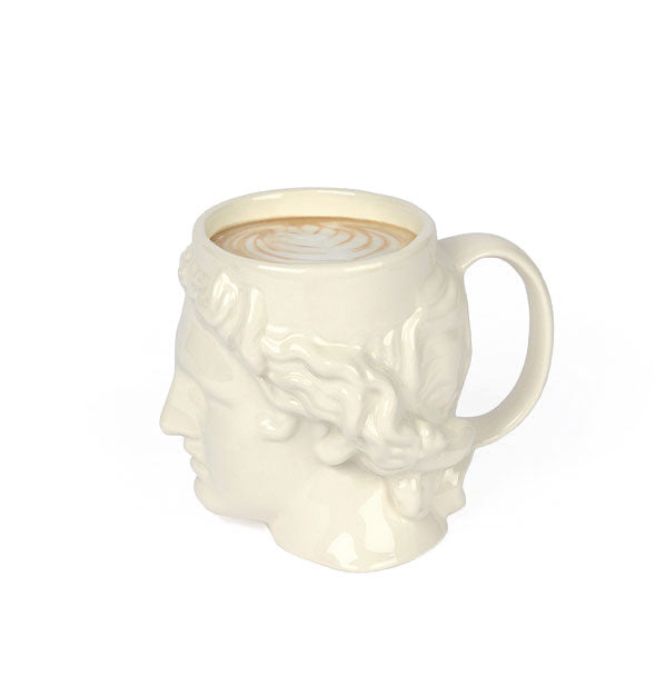Side view of white ceramic Apollo head coffee mug filled with a latte