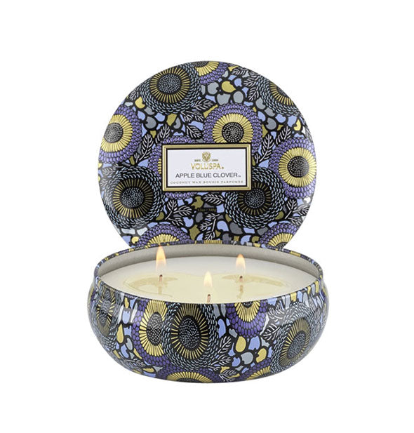 Round candle tin with purple and gold Japonica design on body and lid, set behind