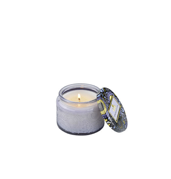 Embossed periwinkle candle glass with matching decorative tin lid to the side